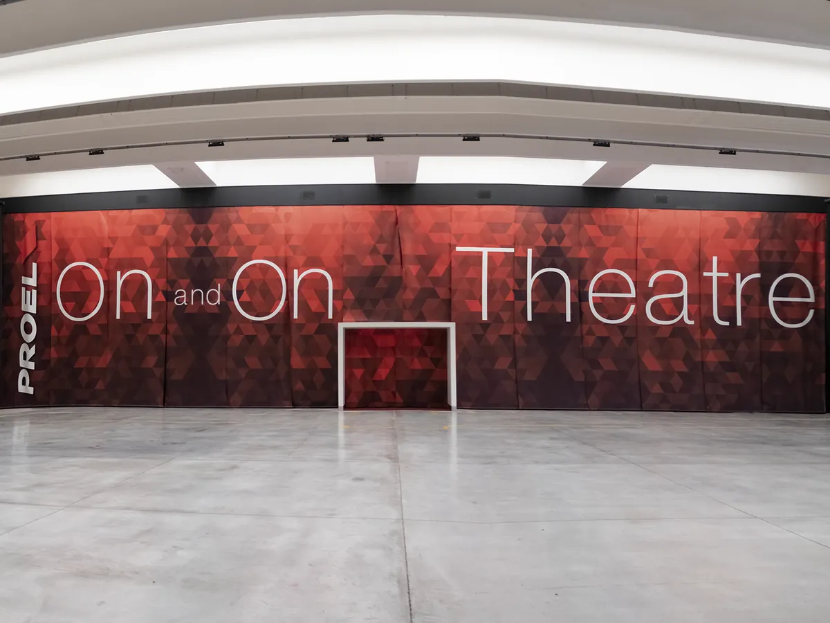 The entrance to the On and On Theatre: a red geometric wall carrying the theatre’s name, inside the hall