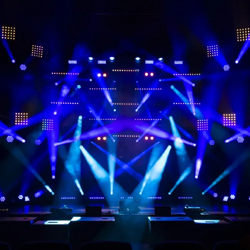 A concert stage under a full rig of blue moving lights